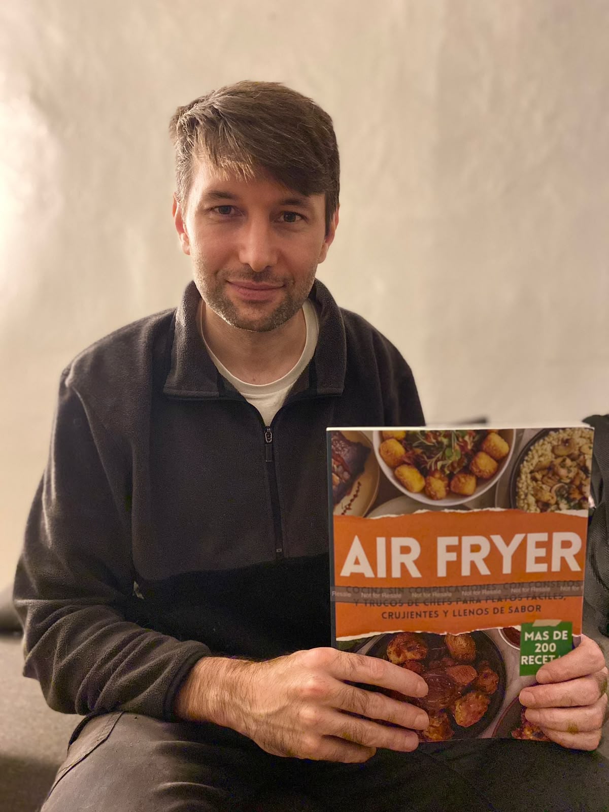 Un estudiante con su libro de recetas de air fryer publicado en Amazon
